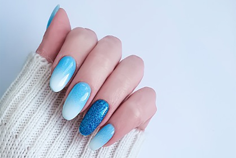  A blue gel nail polish manicure with accent colors.