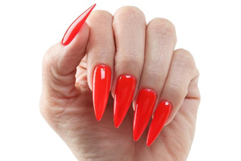 A hand with a glossy red manicure in soft natural light.