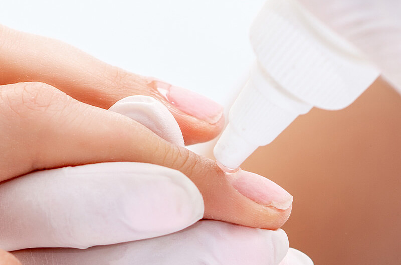 glue being applied to nails.