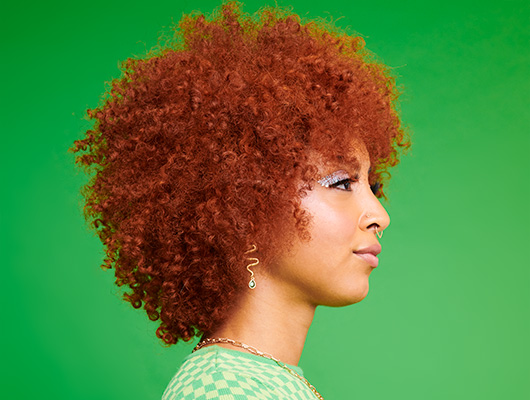 Woman with curly styled copper colored hair
