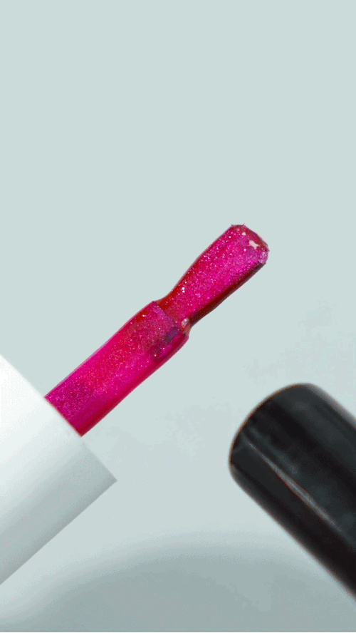 A close-up of shimmering pink magnetic cat eye nail polish on the brush.