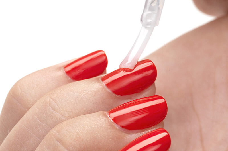 image of top coat on red nails.