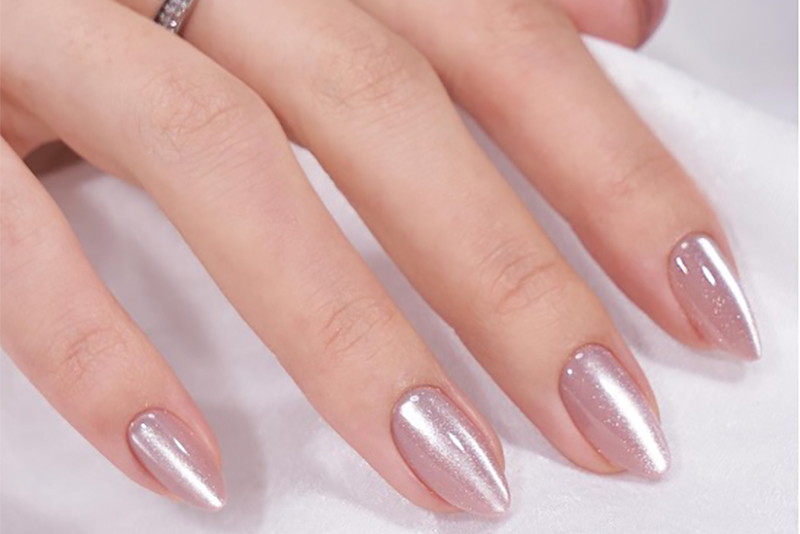 A hand with metallic silver-pink classic vertical cat eye nails.